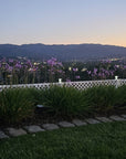 SnapFence white lattice Garden Border Fence along a lawn edge with hills at sunset